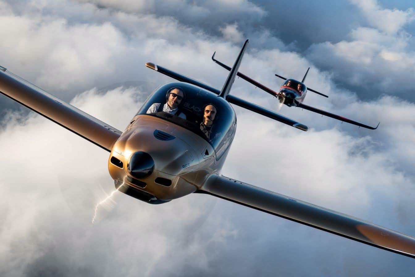 Two pilots flying a Blackwing light sport aircraft above the clouds, with a second Blackwing in formation behind